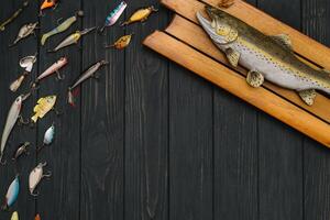 pesca affrontare - pesca Filatura, ganci e esche su scurire di legno sfondo. superiore Visualizza foto