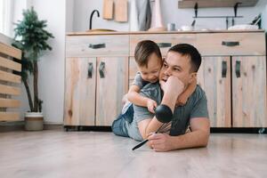 giovane uomo e il suo figlio con forno foglio nel cucina. padre con poco figlio su il cucina foto