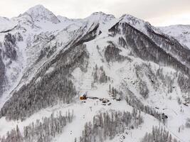un' Visualizza di il Krasnaya polyana sciare ricorrere e il nevoso montagna paesaggi foto