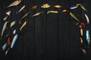 pesca affrontare - pesca Filatura, ganci e esche su scurire di legno sfondo. superiore Visualizza foto