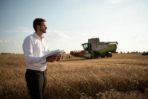 contento contadino nel il campo controllo Mais impianti durante un' soleggiato estate giorno, agricoltura e cibo produzione concetto. foto