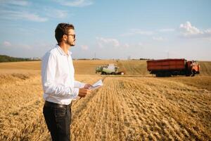 contento contadino nel il campo controllo Mais impianti durante un' soleggiato estate giorno, agricoltura e cibo produzione concetto foto