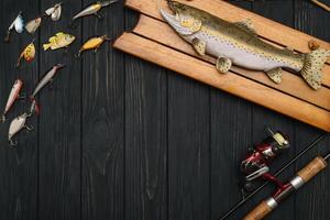 pesca affrontare - pesca Filatura, ganci e esche su scurire di legno sfondo. superiore Visualizza foto