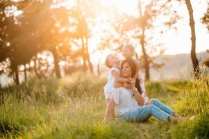 madre e Due figlie avendo divertimento nel il parco. felicità e armonia nel famiglia vita. bellezza natura scena con famiglia all'aperto stile di vita. foto