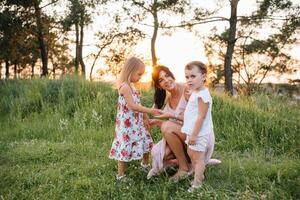 elegante madre e bello figlia avendo divertimento su il natura. contento famiglia concetto. bellezza natura scena con famiglia all'aperto stile di vita. famiglia riposo insieme. felicità nel famiglia vita. madri giorno. foto