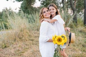 elegante madre e bello figlia avendo divertimento su il natura. contento famiglia concetto. bellezza natura scena con famiglia all'aperto stile di vita. famiglia riposo insieme. felicità nel famiglia vita. madri giorno. foto