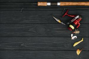 pesca affrontare - pesca Filatura, ganci e esche su scurire di legno sfondo. superiore Visualizza. foto