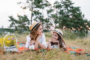 contento donna sorridente e giocando con sua carino poco bambino, dire bugie outdoor.loving madre e figlia trascorrere tempo insieme nel un' parco. mamma e ragazzo ha divertimento. La madre di giorno foto