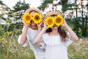 allegro madre e sua poco figlia avendo divertimento insieme nel il estate sfondo. contento famiglia nel il natura sfondo. carino ragazze con colorato fiori foto