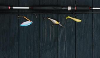 pesca affrontare - pesca Filatura, ganci e esche su scurire di legno sfondo. superiore Visualizza. foto