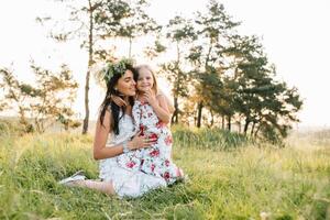 elegante madre e bello figlia avendo divertimento su il natura. contento famiglia concetto. bellezza natura scena con famiglia all'aperto stile di vita. famiglia riposo insieme. felicità nel famiglia vita. madri giorno. foto