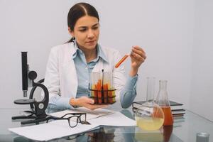 bellissimo medico medici nel guanti e bicchieri siamo Lavorando con sostanze nel test tubi e microscopio a il laboratorio. foto di attraente concentrato femmina medico scrittura prescrizione su speciale modulo