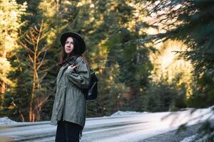 contento ragazza con cappello nel foresta a montagna strada sfondo, rilassare tempo su vacanza concetto viaggio ,colore di Vintage ▾ tono e morbido messa a fuoco. foto