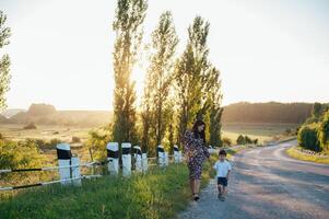 elegante madre e bello figlio avendo divertimento su il natura. contento famiglia concetto. bellezza natura scena con famiglia all'aperto stile di vita. contento famiglia riposo insieme. felicità nel famiglia vita. madri giorno. foto