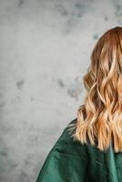 posteriore Visualizza di un' donna con lungo Marrone capelli contro un' grigio sfondo. foto