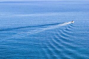 aereo Visualizza di un' minuscolo motoscafo su un' chiaro blu mare con onde. mediterraneo mare, cirali, antalya Provincia nel tacchino. foto