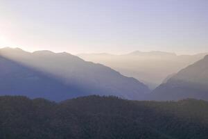 panoramico Visualizza maestoso montagna gamma a tramonto riflettendo su calma mare acque foto