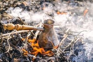 fabbricazione caffè nel cezve su il falò quando campeggio o escursioni a piedi nel il natura. caffè su falò. foto