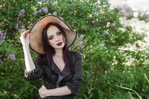 un' alla moda ragazza con buio capelli, un' primavera ritratto nel lilla toni nel estate. luminosa professionale trucco. foto