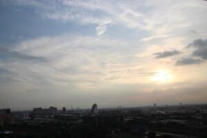 Paradiso nuvoloso cielo giorno sera crepuscolo tempo con luce del sole raggio a partire dal fra nuvole con città cittadina sfondo foto