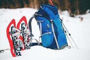 zaino, ciaspole e bastoncini da trekking. foto