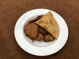 solated superiore Visualizza di qema samosa e bacino pakora nel bianca piatto, popolare indiano o pakistano strada cibo merenda su bianca sfondo, Diwali cena o iftar pasto. foto