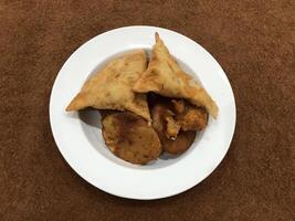 solated superiore Visualizza di qema samosa e bacino pakora nel bianca piatto, popolare indiano o pakistano strada cibo merenda su bianca sfondo, Diwali cena o iftar pasto. foto