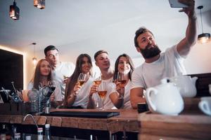 concetto di tempo libero e comunicazione. gruppo di amici sorridenti che si godono un drink e parlano al bar o al pub foto