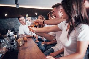 concetto di tempo libero e comunicazione. gruppo di amici sorridenti che si godono un drink e parlano al bar o al pub foto