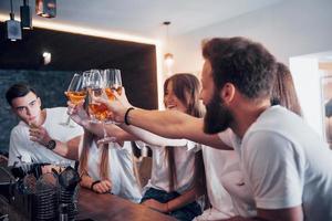 concetto di tempo libero e comunicazione. gruppo di amici sorridenti che si godono un drink e parlano al bar o al pub foto