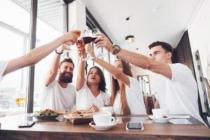 amici si sono riuniti a tavola con cibo delizioso con bicchieri di vino rosso per festeggiare un'occasione speciale foto