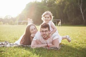 famiglia felice, padre di madre e figlia del bambino nella natura al tramonto foto