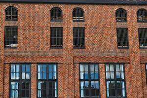 facciata di un' Vintage ▾ mattone edificio con righe di finestre riflettendo il cielo, in mostra industriale architettura nel York, nord yorkshire, Inghilterra. foto