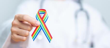 medico con LGBTQ arcobaleno nastro per supporto lesbica, gay, bisessuale, transgender e strano Comunità e contento orgoglio mese concetto foto