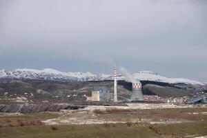 termico energia stazione espellendo inquinanti per il aria. città con povero aria qualità dovuto per termico energia pianta. ardente fossile carburante. tossico aria per persone nel il città. foto