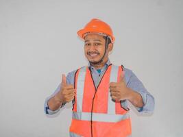 un' uomo indossare costruzione elmetto protettivo sorridente e dare Due pollici su foto