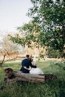 lo sposo e la sposa stanno camminando nella foresta vicino a un fiume stretto foto