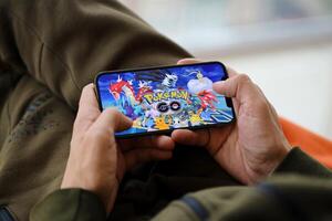 Pokemon partire mobile ios gioco su i phone 15 smartphone schermo nel maschio mani durante mobile gameplay foto
