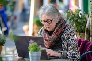 vecchio signora Lavorando a il computer portatile comunicare o fare networking attività commerciale foto