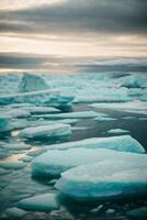 iceberg galleggiante nel il acqua a tramonto foto