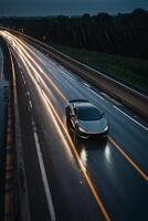 un' gli sport auto guida giù un' bagnato strada a notte foto