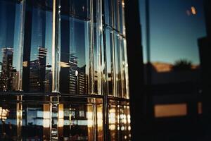 un' edificio con un' grande bicchiere parete e un' tramonto foto