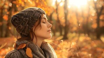 tranquillo, calmo donna nel accogliente maglia strillone berretto si crogiola nel autunno sole in mezzo d'oro foresta fogliame foto