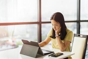 donna premurosa che lavora al computer tablet a casa. foto