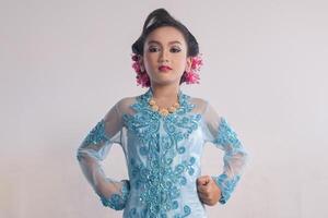 un indonesiano 10 anni vecchio ragazza indossare giavanese tradizionale Abiti chiamato kebaya con fiducia posa foto