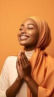 africano donna indossare sciarpa è preghiere e sorridente su Marrone sfondo foto