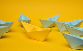 un' gruppo di blu carta Barche circondato uno giallo barca, il concetto di bullismo foto