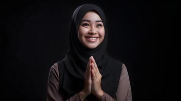 sud-est asiatico donna indossare sciarpa è preghiere e sorridente su nero sfondo foto