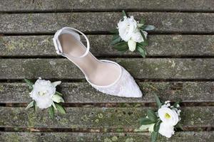 scarpa da sposa bianca con fiori bianchi su vecchie tavole di legno foto