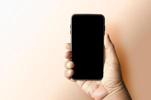 mano dell'uomo che tiene lo sfondo dello smartphone isolato in bianco foto